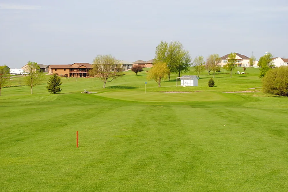Looking down a wide fairway from the tee marker toward the green